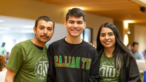 A student and his parents wearing UTD T-shirts.