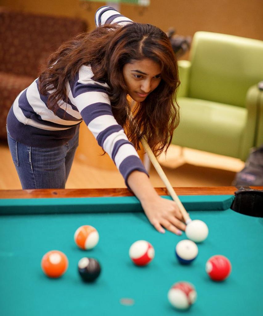 a student playing billiards