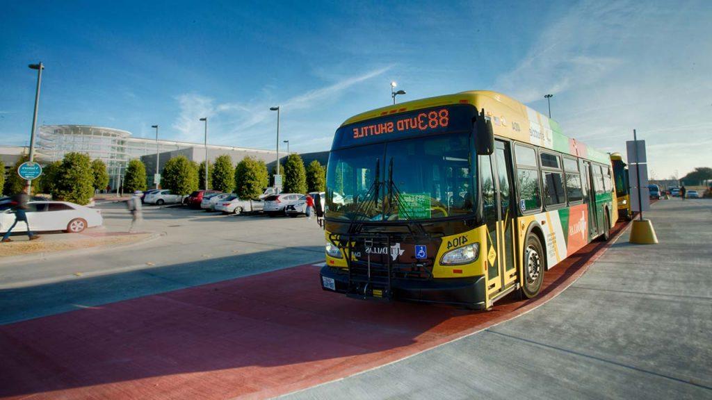 An 883 UTD-DART bus pulls up outside the Visitor Center. 