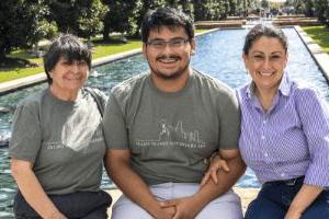 Family pose with a student on campus